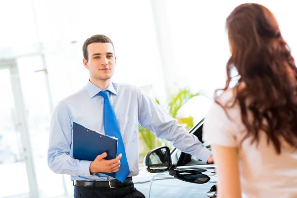 Sales manager at a showroom car — Stock Photo, Image