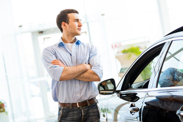 мужчина, стоящий рядом с автомобилем
