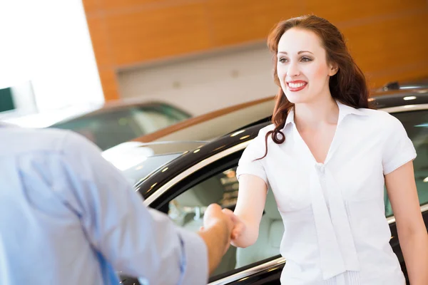 Mujer estrechando la mano con vendedor de coches — Foto de Stock