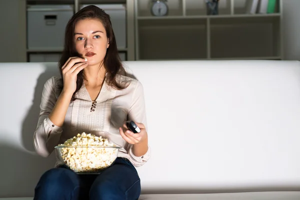 Jonge vrouw kijkt TV — Stockfoto