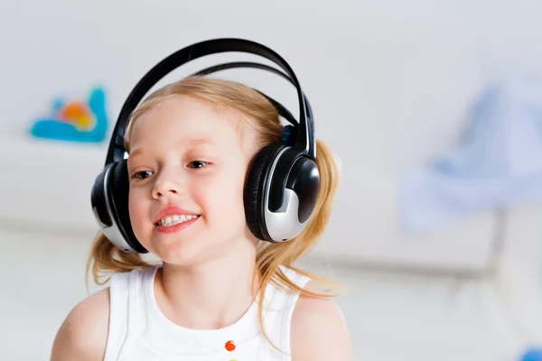 Menina bonita ouvindo música em fones de ouvido — Fotografia de Stock