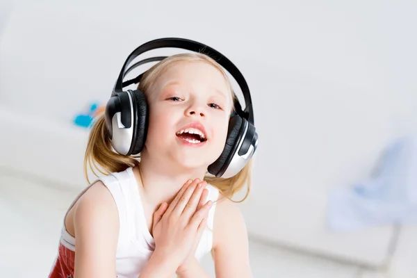 Menina bonita ouvindo música em fones de ouvido — Fotografia de Stock