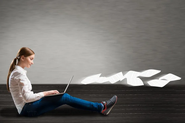 Giovane ragazza seduta sul pavimento con un computer portatile — Foto Stock
