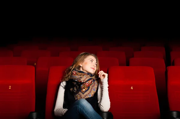 Ung attraktiv kvinna sitter i en biograf — Stockfoto