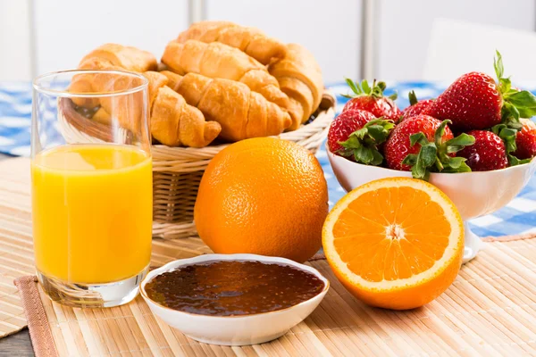 Tidig frukost, juice, croissanter och sylt — Stockfoto