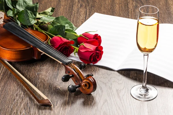 Skrzypce, róża, kieliszek szampana i muzyka książki — Zdjęcie stockowe