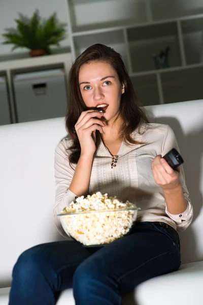 Jonge vrouw kijkt TV — Stockfoto
