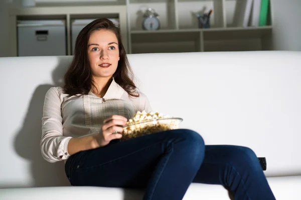 Jonge vrouw kijkt TV — Stockfoto