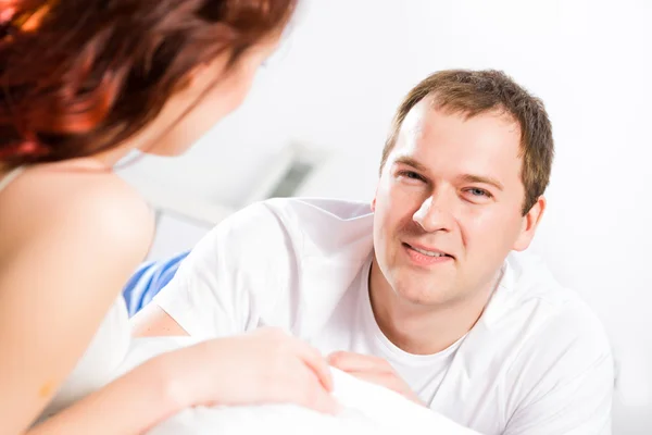 Jonge man liggend in bed met zijn vriendin — Stockfoto