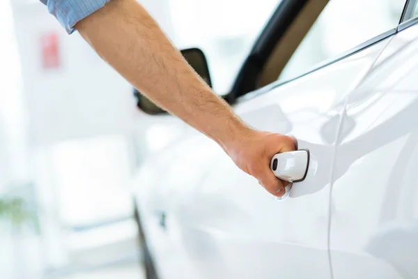 Homem abre a porta para um carro novo — Fotografia de Stock