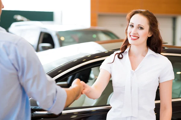 女人与汽车推销员握手 — 图库照片