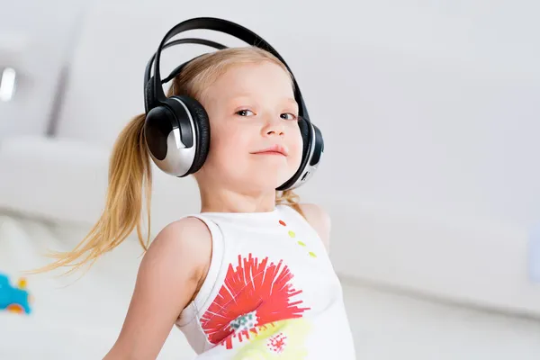 Menina bonita ouvindo música em fones de ouvido — Fotografia de Stock