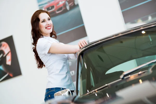 Jonge vrouw permanent in de buurt van een auto — Stockfoto