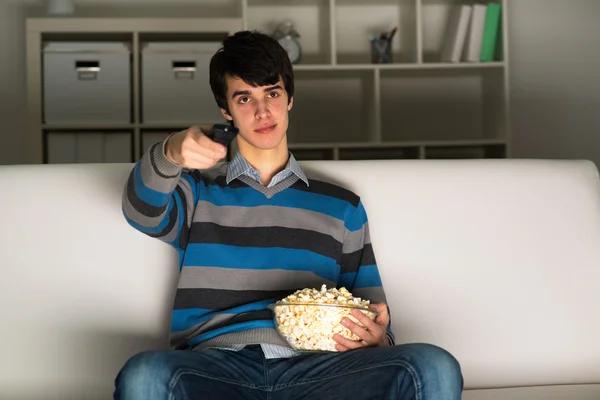 Young man watching television with popcorn — Stock Photo, Image