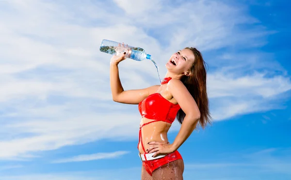 Fată sport în uniformă roșie cu o sticlă de apă — Fotografie, imagine de stoc