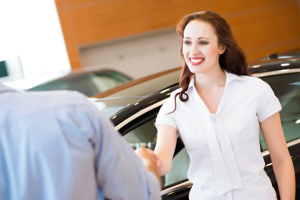 Woman shaking hands with car salesman — Stock Photo, Image