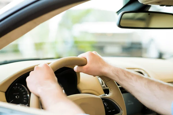 Male hand holding a car wheel — Stock Photo, Image