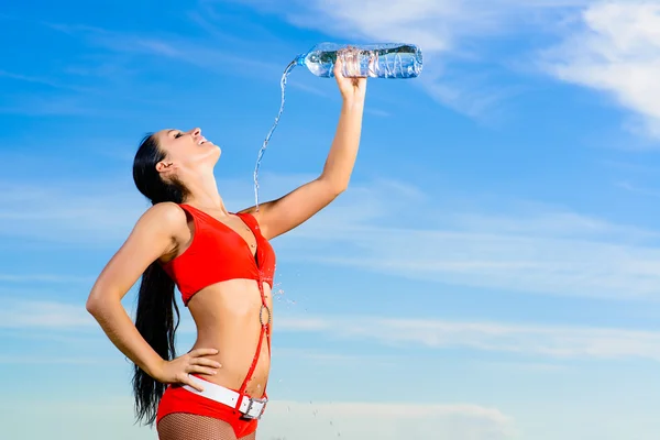 Sport girl in red uniform with a bottle of water — Stock Photo, Image