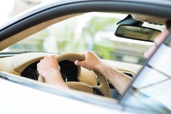 Mão masculina segurando uma roda de carro — Fotografia de Stock