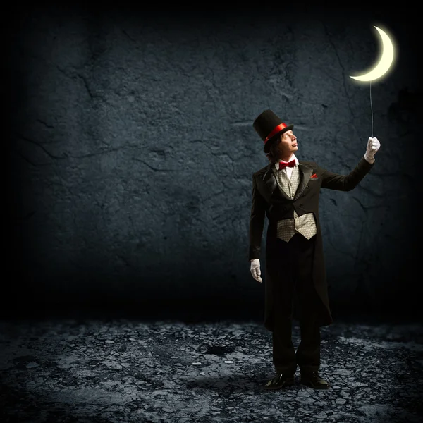 Magician keeps the moon on a string Royalty Free Stock Images
