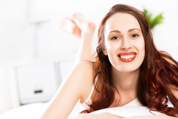 Portret van een jonge vrouw in de slaapkamer — Stockfoto