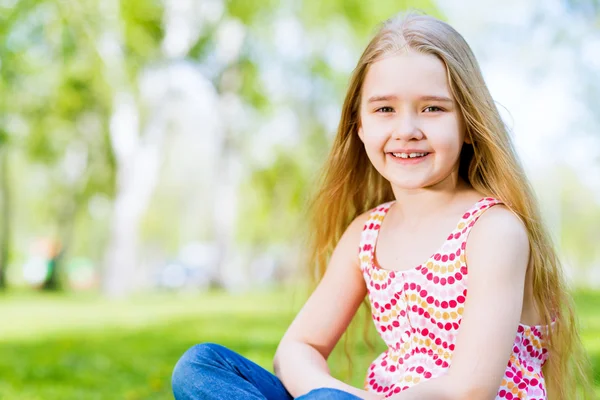 Portrait of a smiling girl in a park — Stock Photo, Image