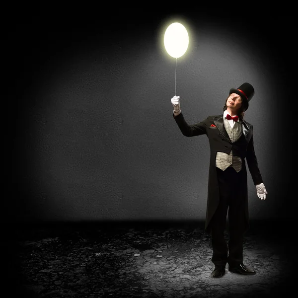 Magician holding a glowing balloon Royalty Free Stock Images