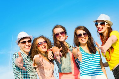 güneş gözlüğü ve şapka giyen genç grup