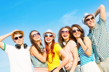 güneş gözlüğü ve şapka giyen genç grup