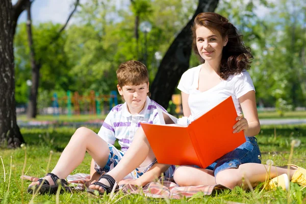 Girl and a young woman reading a book together — Stock Photo, Image