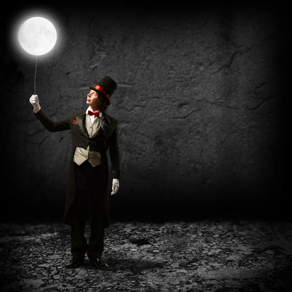 Magician keeps the moon on a string Stock Photo