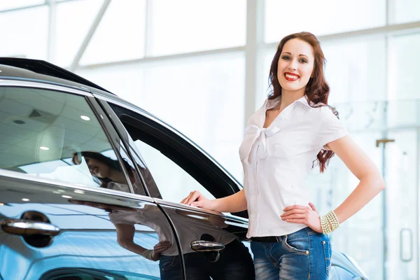 Jeune femme debout près d'une voiture — Photo