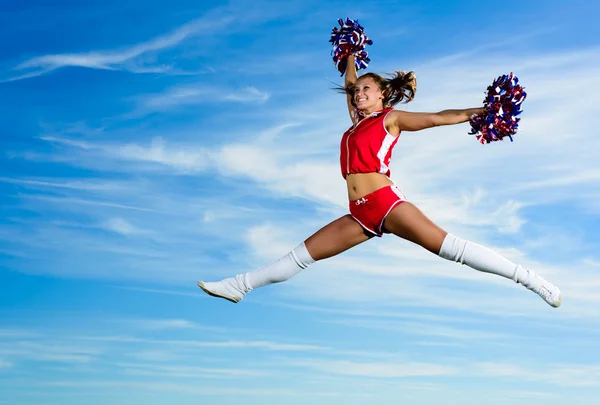 Giovane cheerleader in costume rosso saltando — Foto Stock