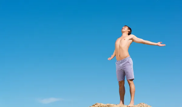 Homem sem camisa contra o céu azul — Fotografia de Stock
