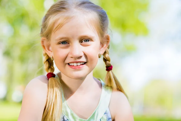 Portret van een glimlachende meisje in een park — Stockfoto