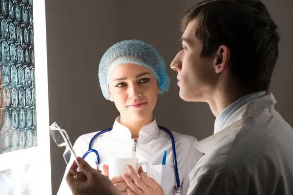 Медицинские коллеги совещаются возле рентгеновского снимка — стоковое фото