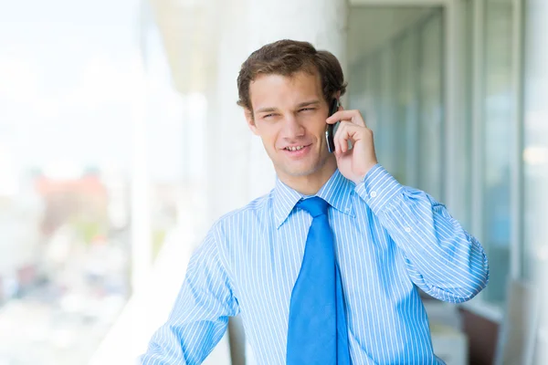 Ung affärsman talar i mobiltelefon — Stockfoto