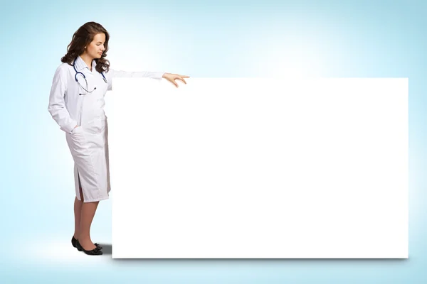 Junge Ärztin steht neben einem leeren Banner — Stockfoto