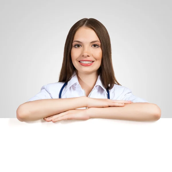 Young woman doctor with a blank banner — Stock Photo, Image