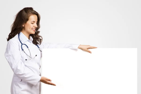 Young woman doctor with a blank banner — Stock Photo, Image