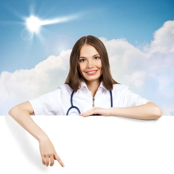 Young woman doctor with a blank banner — Stock Photo, Image