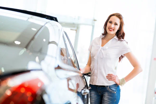 Ung kvinne som står ved en bil – stockfoto