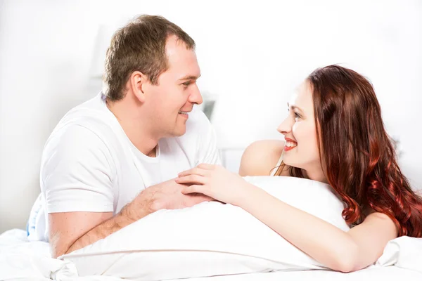 Jeune homme et femme couchés ensemble au lit — Photo