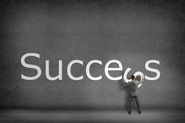 Businessman collects on the wall the word success — Stock Photo, Image