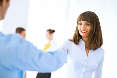 bir müşteri ile el sıkışan iş kadını