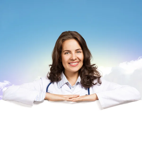 Young woman doctor with a blank banner — Stock Photo, Image