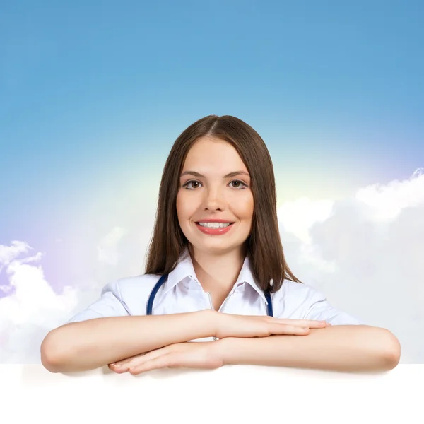 Young woman doctor with a blank banner — Stock Photo, Image