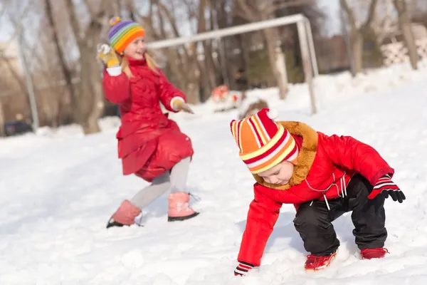 Lekande barn i Vinterparken snöbollar — Stockfoto