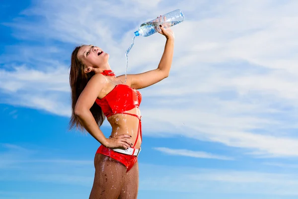 Ragazza sportiva in uniforme rossa con una bottiglia d'acqua — Foto Stock