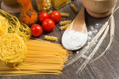 makarna, domates ve un üstünde kaşık